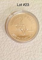 Front side of the 1975 Calgary Centennial Canadian Silver Dollar showing the cowboy on bucking bronco with city skyline and oil wells in background, encased in a clear plastic holder.