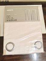Packaged pair of IKEA MERETE white room darkening curtain panels with visible grommets and packaging