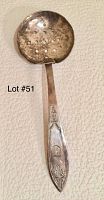 Silver spoon with pierced bowl, showing tarnish, monogram on handle, detached head separated from handle.