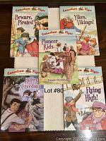 Set of five Canadian Flyer Adventures children's books by Frieda Wishinsky displayed on a table, showing front covers with illustrated historical scenes.