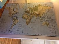 Full view of the world map printed on canvas showing entire map layout and frame edges.