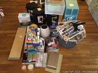 Various household items including hangers, ironing accessories, shelf mats, rolled beach mats, jewelry boxes, and a Holmes air purifier on hardwood floor.
