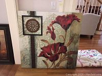 Full frontal view of framed canvas art showing red floral painting and metal scrollwork centerpiece.