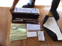 Overall view of flute case, flute sections, invoice, booklets and cleaning cloths.