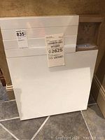 Photo showing the corner piece of the flat packed IKEA table still in white protective wrapping with barcode labels attached.