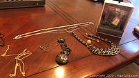 Photo of Treks headphones box, three jewelry chains including a Big Ben pocket watch