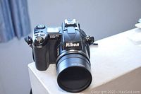 Nikon Coolpix 5700 digital camera front and side views showing lens and controls