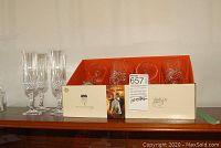 Set of 8 crystal stemware on display with boxes and packaging behind including 4 water glasses and 4 wine flutes.
