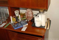 Himalayan salt lamp, candles, incense including cones, candle holders, snuffers, Ravenhead glass coasters, and a silver solar light on wooden surface