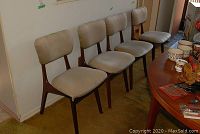 Four chairs in a row against a wall on floor covering