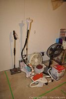Full view of all items in lot including humidifier, fans, sweeper, scale, and steamer.