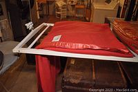 Red wool blanket folded on a rack showing the satin edging and a close-up view of the texture and label.