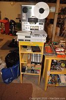 Overall view of Sony tape recorder on yellow stand with network and telecom devices below