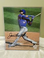 Signed 8x10 print of Jose Bautista in Blue Jays uniform, mid-swing, with autograph and number 19.