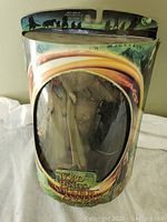 Front view of sealed packaging showing faint outlines of Sauron and Gandalf toy figures inside.