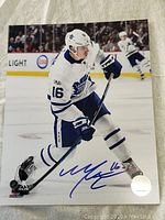 Full view of 8x10 photo signed by Mitch Marner in Toronto Maple Leafs uniform, showing autograph prominently on lower portion.