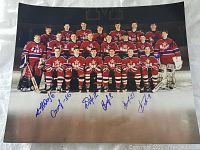 Color photo of 1990 Russian National hockey team group portrait with visible player autographs in blue ink on white border