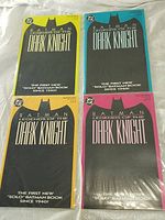 Four Batman Legends of the Dark Knight comics laid out on a surface showing colored borders and titles