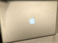 Top view of closed silver Apple MacBook Pro laptop showing Apple logo with scratches and wear on surface.