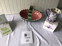 Photo showing the ceramic watermelon bowl, mug with paw prints and text, and boxed coasters together on table.