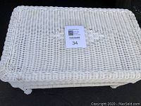 Top view of the white composite wicker table showing woven rectangular surface with braided wicker edge.