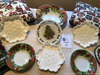 Photo showing all items laid out including three Christmas pillows, two round plastic bowls with holly and Christmas tree designs, and four white snowflake-shaped plastic trays.