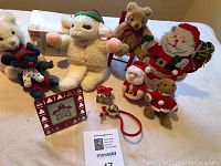 Lot contents arranged on table including plush toys, Christmas frame, and holiday decorations.