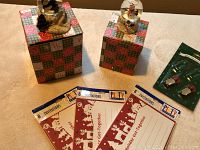 Photo showing two snowman belly globe ornaments each placed on a gift-wrapped base and four invitation card packages.