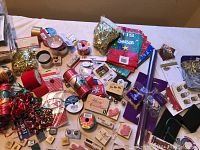 Photo of assorted holiday stamps, stamp pads, gift bags and ribbons spread out on a surface showing multiple items
