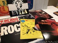 Vinyl record albums shown on a table, mostly original movie soundtracks including Evita, Rocky, and Shaft, with colorful covers visible.