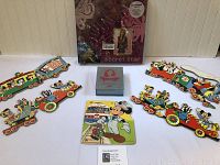 Wide photo showing all items in the lot including puzzles, Cinderella set and scrapbook.