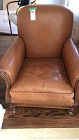 Front view of tan leather armchair showing overall shape and condition