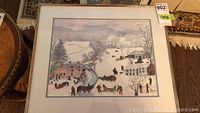 Framed print view showing a winter landscape with horses and people in snow.