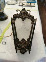Front view showing cast iron frame with floral etching on beveled glass panels.