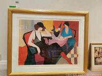Overall front view of framed print showing two women seated at a table