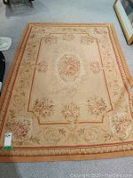Full top view of the rectangular woven floral rug laid out flat on the floor, showing overall pattern and colors.