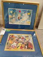 Overview of both framed prints stacked on carpet