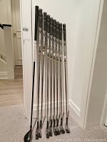 All nine clubs leaning against wall