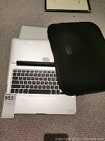 Two closed MacBook Pros stacked with Zagg keyboard and Tumi neoprene sleeve