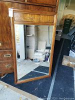Full view of the 30x49 fruitwood framed mirror showing natural wood grain and beveled glass in a room setting.