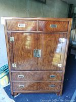 Front view showing two upper drawers, double door cabinet, and two bottom drawers with brass hardware on a fruitwood finish armoire.