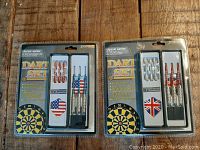Two sealed dart sets, one with American flag design flights and one with British flag design flights in original packaging.