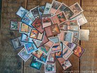 Collection of 43 Magic: The Gathering cards laid out on wood surface, displaying colorful artwork on front sides.