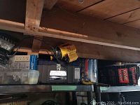 Photo showing various tools and hardware on shelf including Mastercraft parts cabinet, toolbox, power bar, and pack of bungee cords.