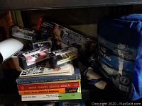 Stack of automotive manuals with a few die-cast models and car care items visible