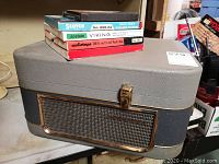 Photo of the closed portable Philips reel to reel player case with several reels of tape stacked on top