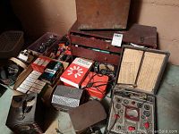 Overall lot view showing wooden toolbox, tube boxes, tester and cases