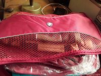 Pink/red packing cube with mesh section showing the Heys logo