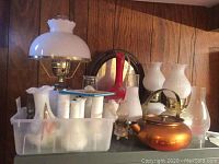 Overall lot on table: hob nail lamps, white glass vases, copper kettle, brass bell, gone with the wind lamp, mirror in back