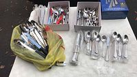 Overall view of flatware spread on table, including boxed and loose pieces